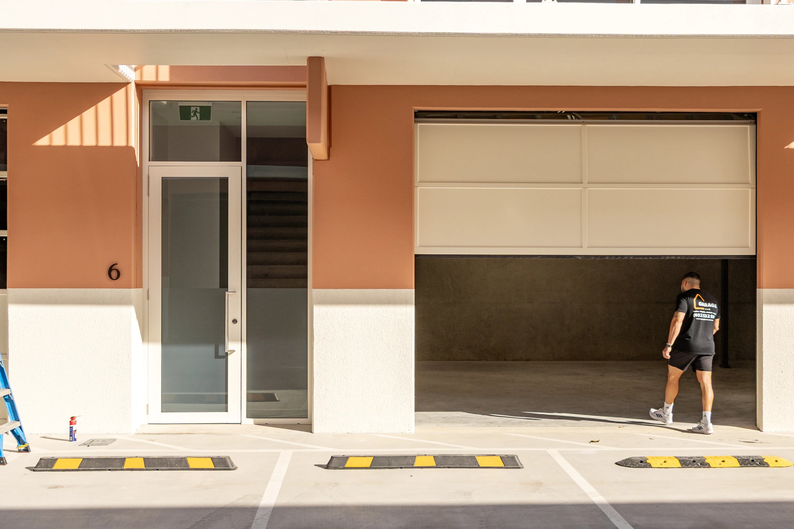 Garage Hub Technician walking towards a garage door in an industrial area