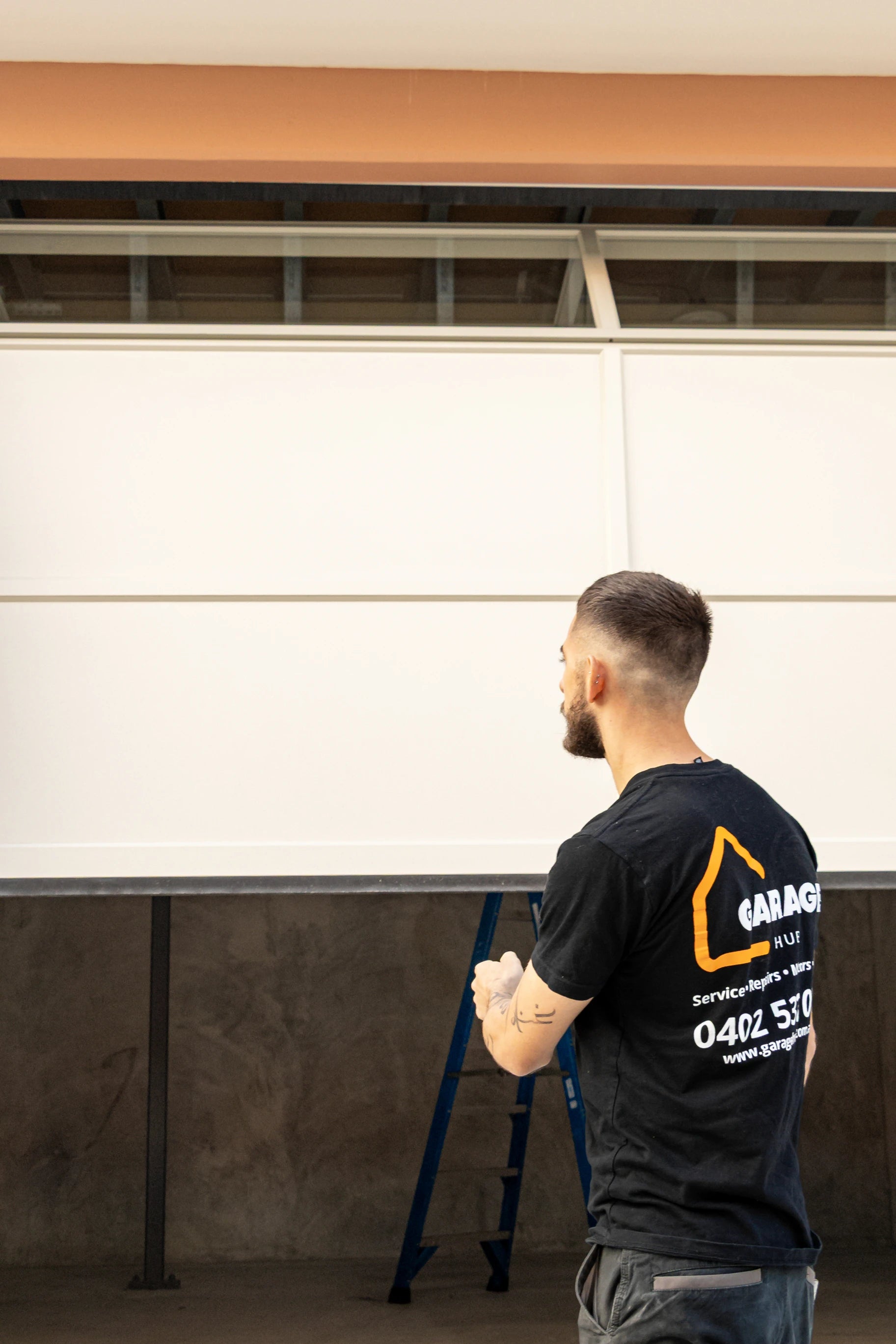 Garage door technician testing garage door remote on newly installed garage door.