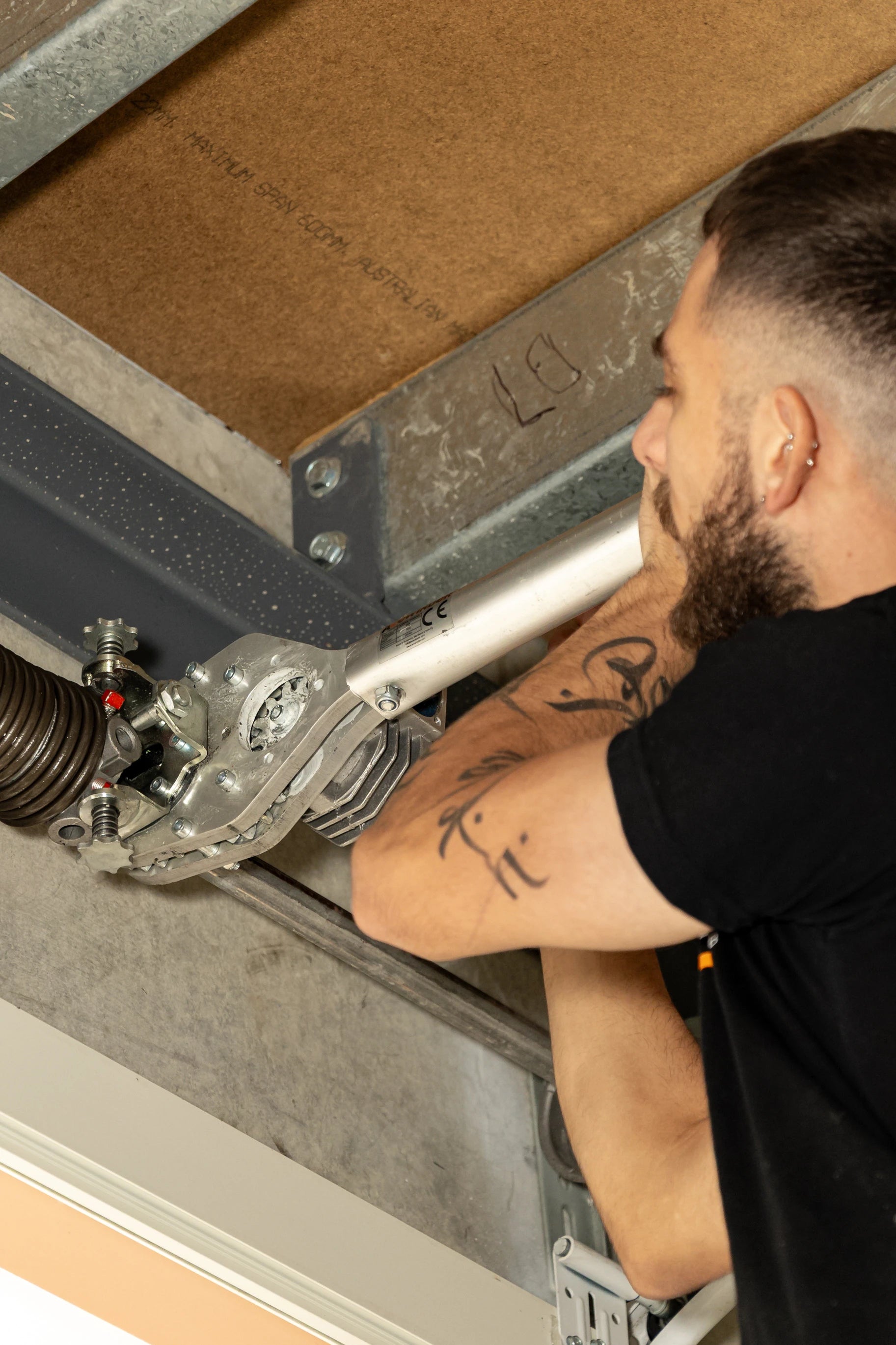 Garage technician working on a garage door spring system.
