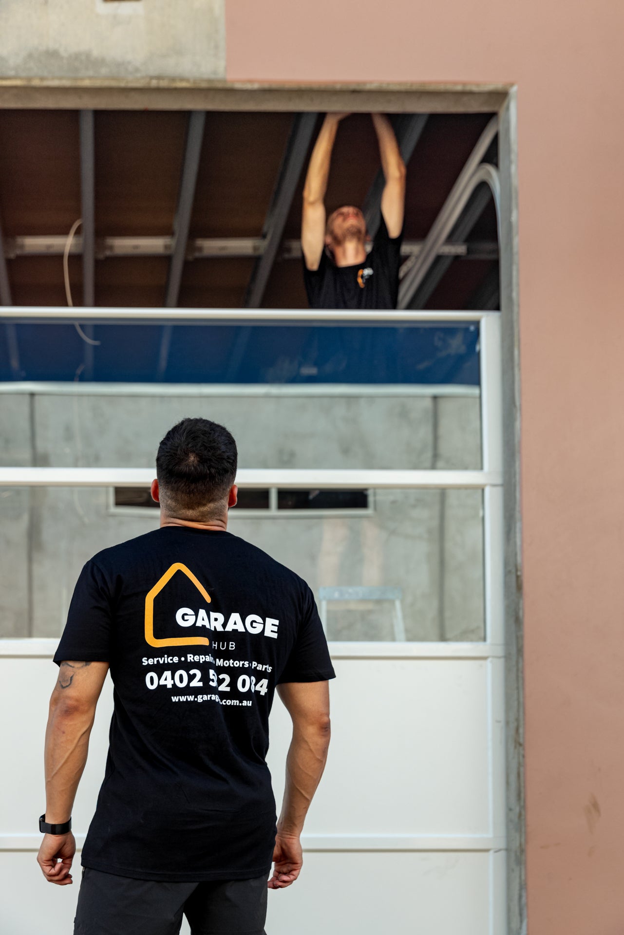 Garage hub technicians inspecting and fitting garage door panels.